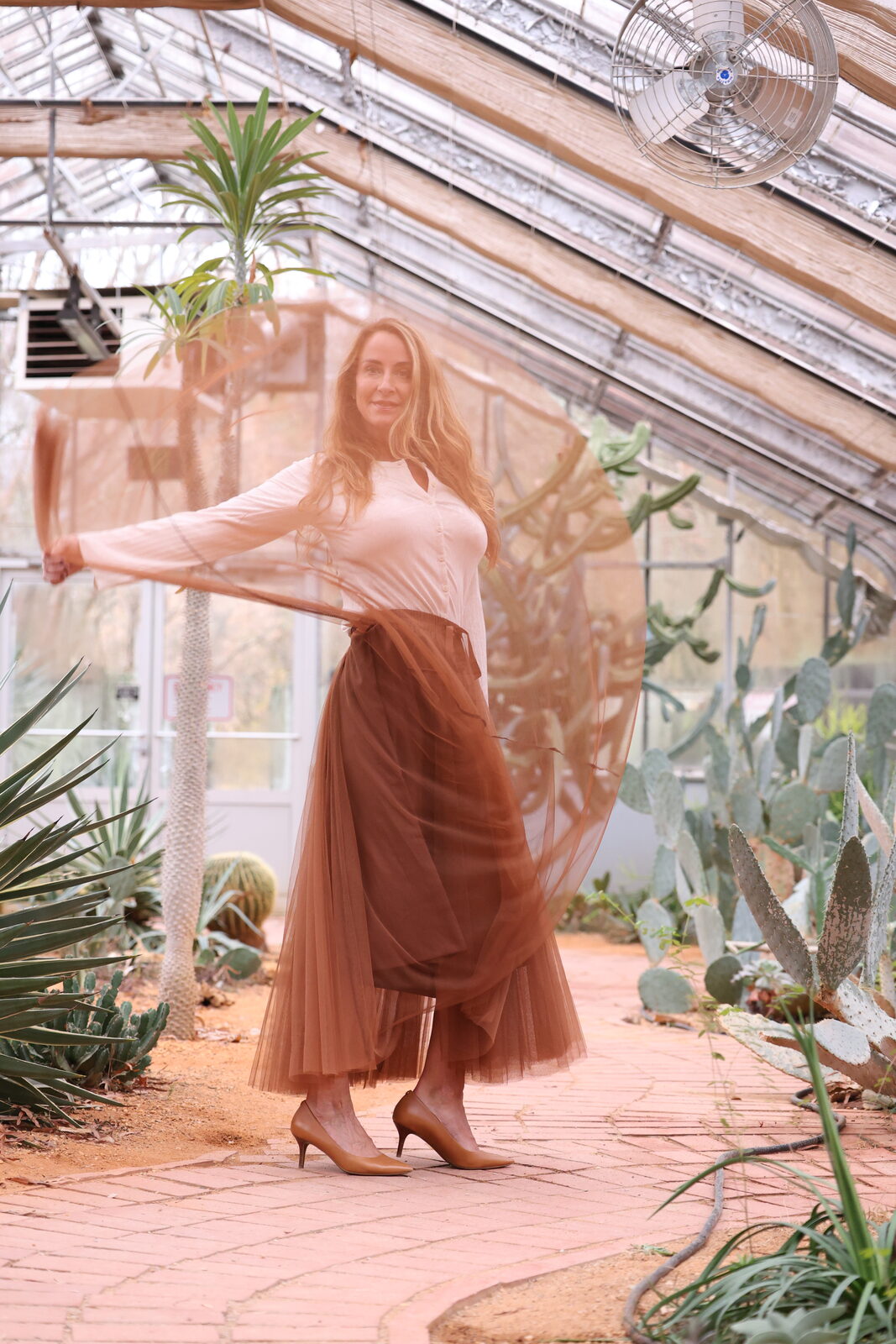 Tracey Abbott in a glasshouse, brown tulle sweeping up past her face
